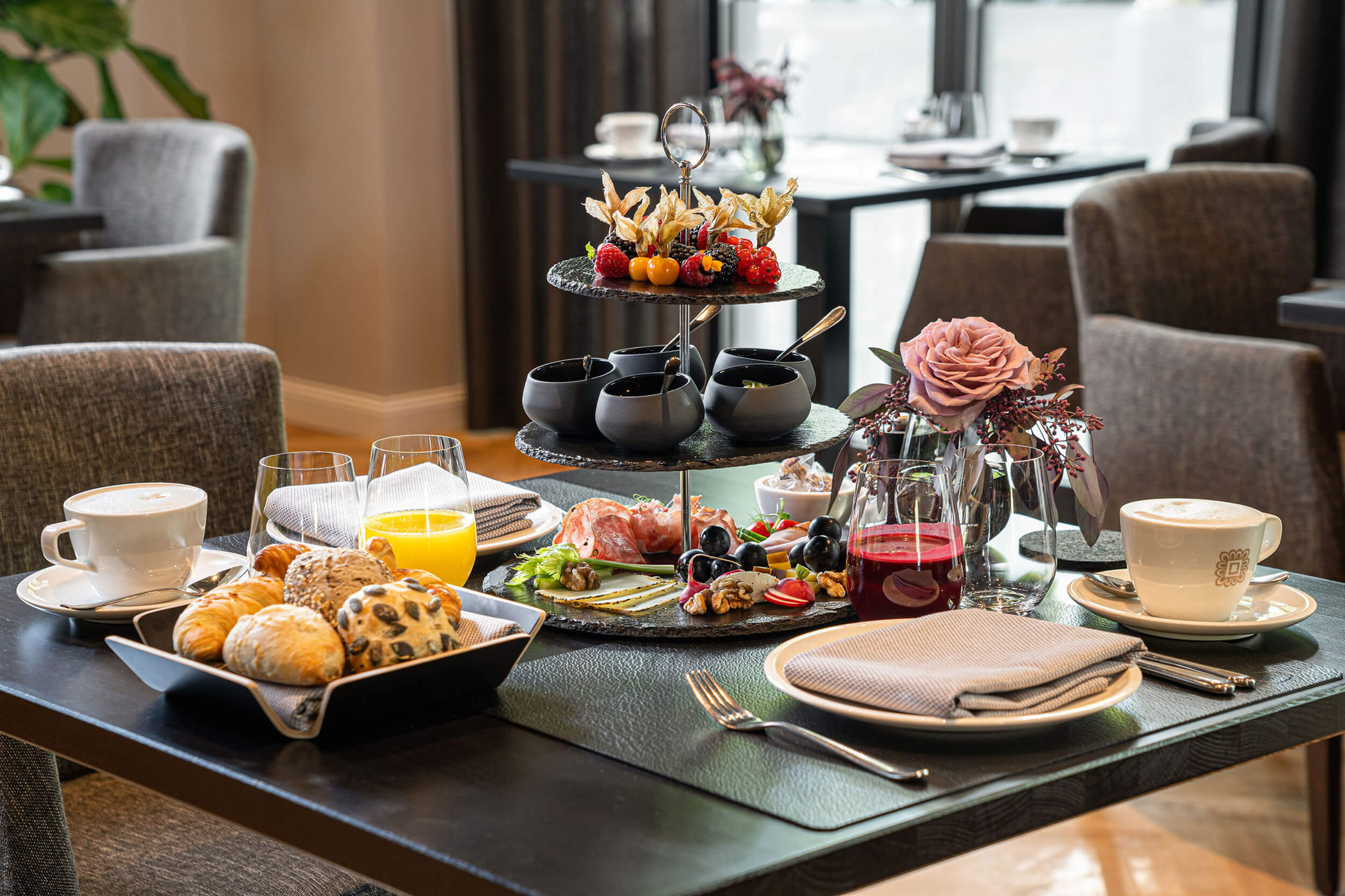 Fruehstueck im Fruehstueckssalon des Hotels. Es zeigt einen gedeckten Tisch mit angerichtetem Fruehstueck. Im Hintergrund sind weitere gedeckte Tische zu sehen. Die Datei ist ein Foto im JPEG-Format.